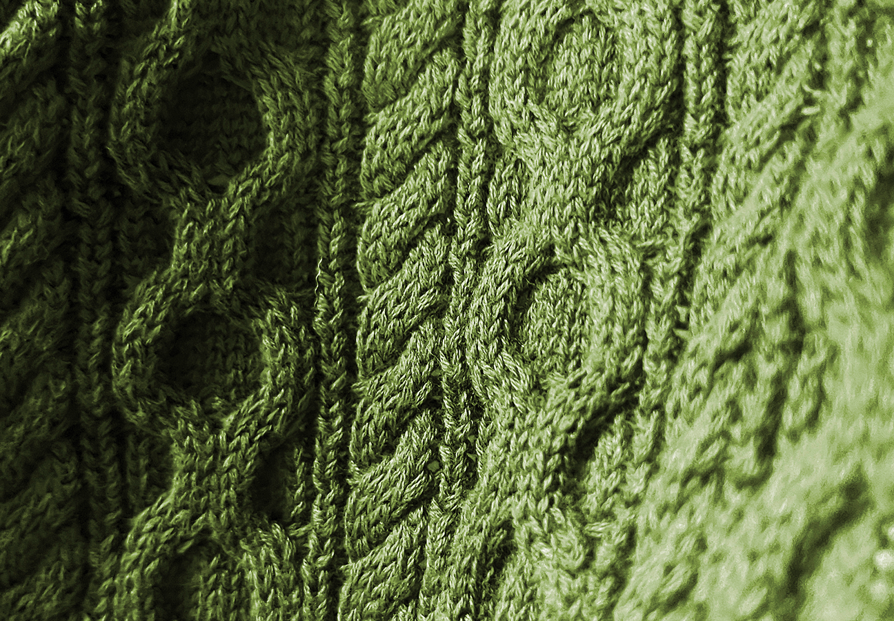 A close-up of a green cable knit swatch.